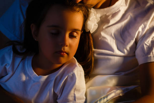 istock Little daughter fell asleep at the father while reading the book 908635882