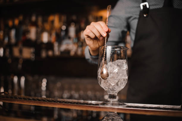 istock Barman stirring ice cubes with help of spoon 908635938