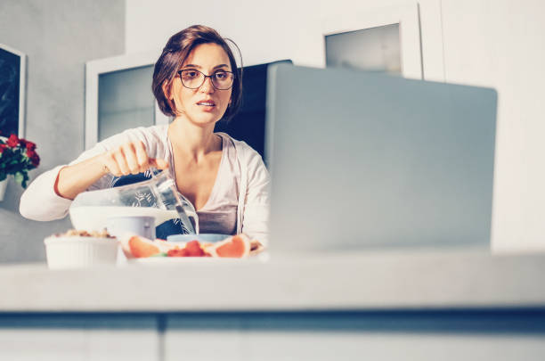istock Woman prepare breakfast and watch laptop on kitchen 908636470
