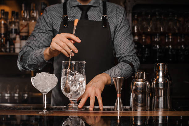 istock Barman making a cocktail with help of the bar equipment 908636548