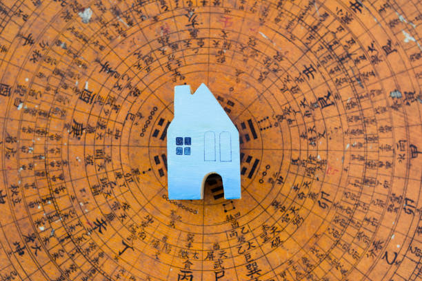 casa in miniatura in legno blu su antica bussola feng shui sfocata - feng foto e immagini stock