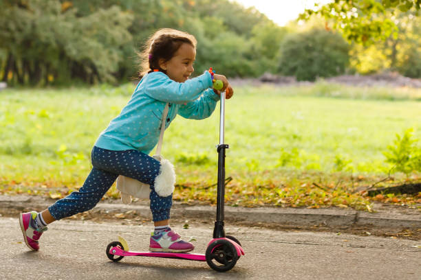 istock Mother Teaching Daughter To Ride Scooter 908639626