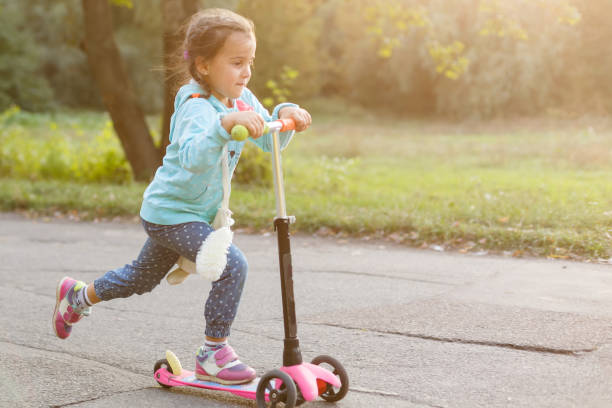 istock Mother Teaching Daughter To Ride Scooter 908639678