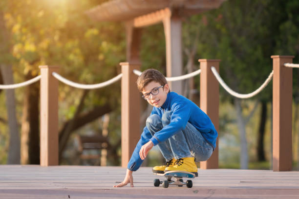 istock Young happy boy with skateboard on the park 908640654