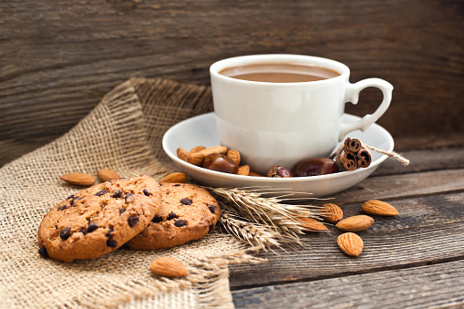 Coffee in a cup with cookies and nuts closeup