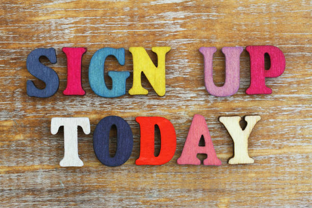 istock Sign up today written with colorful letters on rustic wooden surface 908643652
