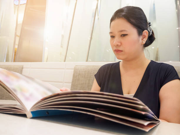 istock Beautiful young asian woman with menu in restaurant 908643884