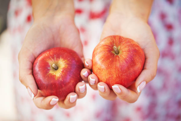 istock Woman keep red apple outdoor. 908643914