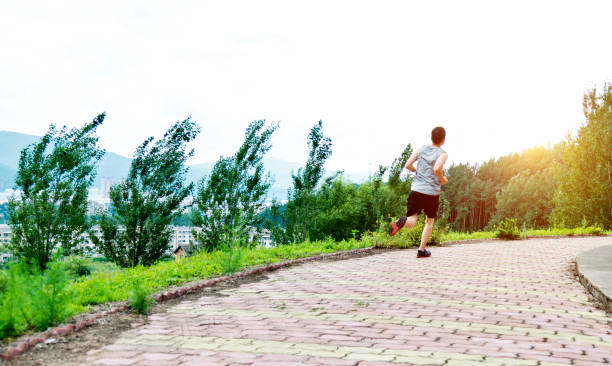 istock Man running on brick road of park 908654412