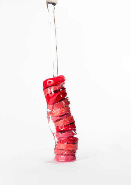 Stack of sliced moisturizing lipsticks with nourishing oil, pouring on them