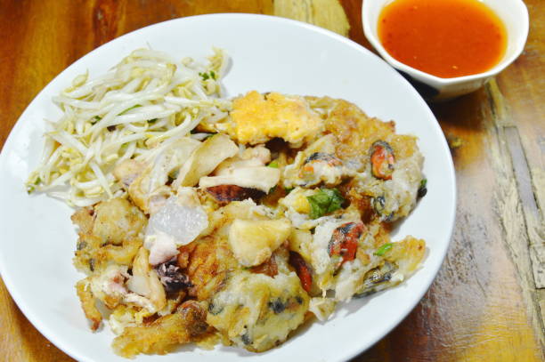istock crispy fried mussel and squid omelet with bean sprout dipping chili sauce 908660672
