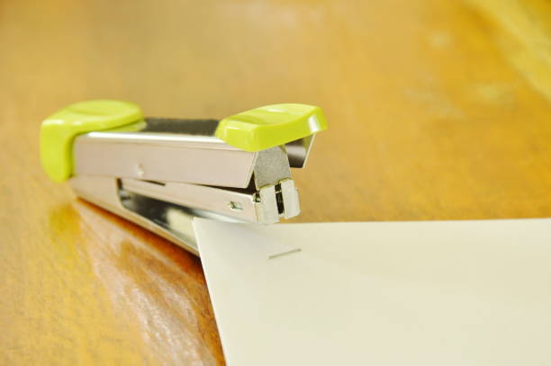 stapler pushing white paper on table - table toughness steel pattern imagens e fotografias de stock