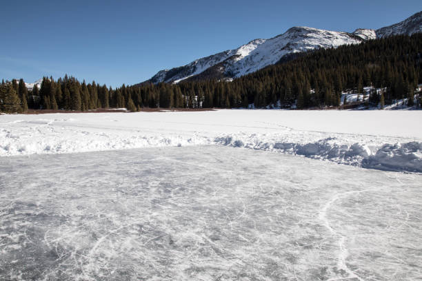 istock Frozen pond ice rink and mountains in Colorado 908665018