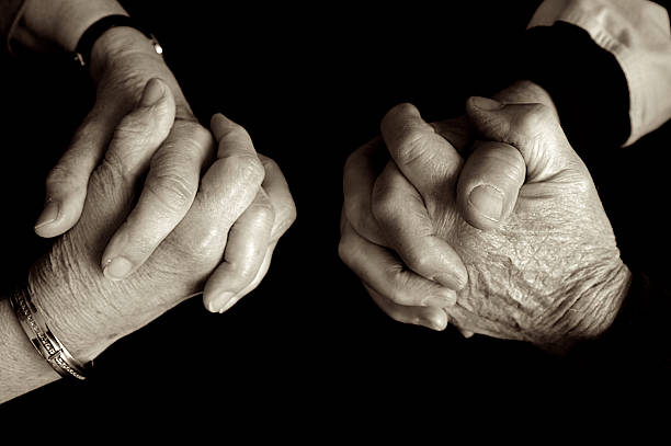 Elderly couple praying.  whitsun stock pictures, royalty-free photos & images