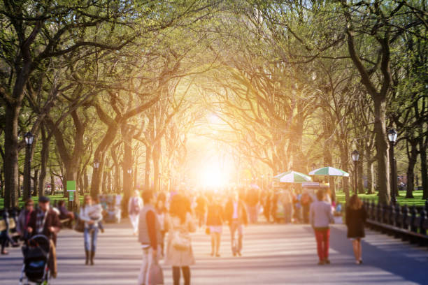 Crowd of anonymous people walking through Central Park New York City
