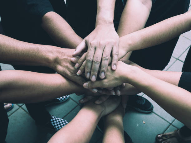 istock Teamwork concept; many people standing hands together in field before starting competition game 908675132