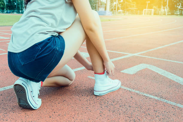 istock Woman runner tying shoelace on running racetrack 908678330