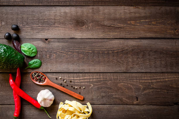 istock Fresh vegetables and pasta on wooden background. Flat lay, top view. Food frame 908685708