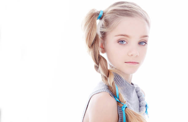 Young blond woman looking into camera on white background