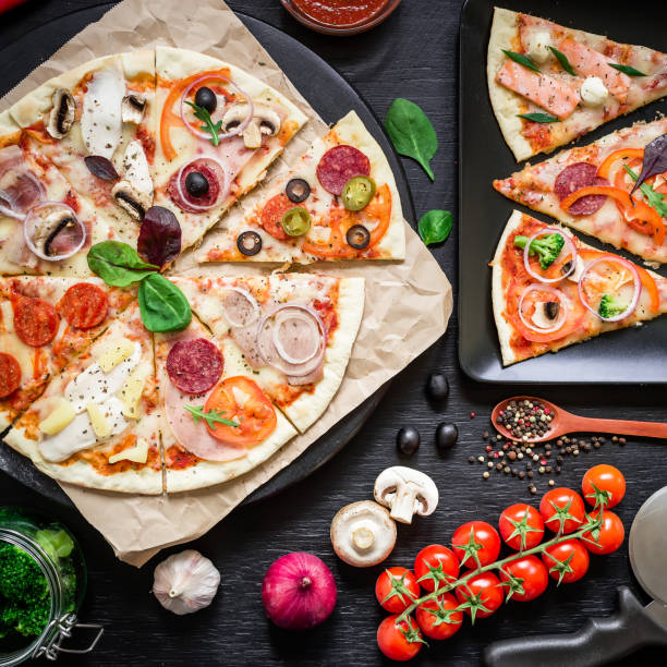 istock Tasty pizza with ingredients, spices on black background. Flat lay, top view. 908686316