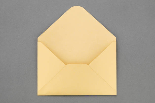 istock Open yellow paper envelope on gray background. 908692068