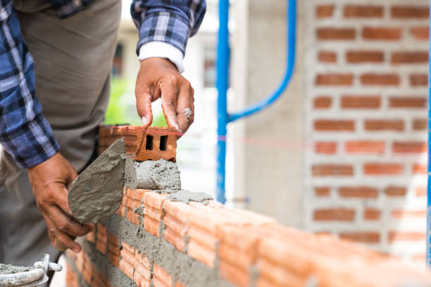 istock Brickwork walls, technicians are forming brick walls with mortar (cement, sand) by using a trowel as tools in Project House construction 908692126