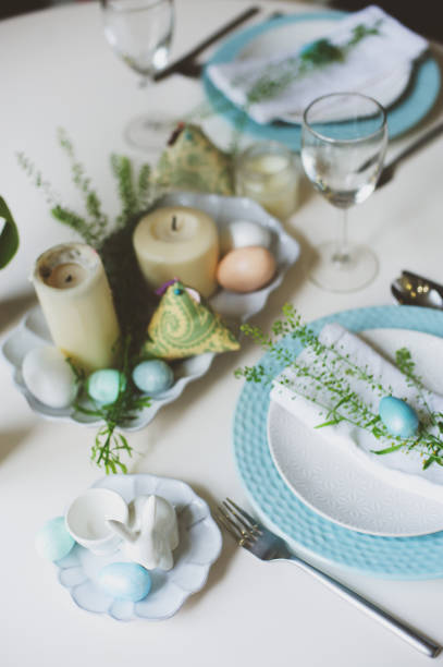 istock easter and spring festive table decorated in blue and white tones in natural rustic style, with eggs, bunny, fresh flowers and candles. 908692658
