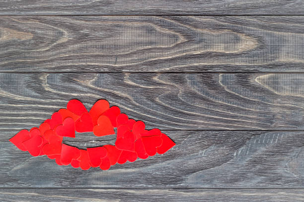 Lips of little red hearts on a wooden background. The concept of Valentine's Day. Lips of little red hearts on a wooden background. The concept of Valentine's Day. knitting textile wool infinity stock pictures, royalty-free photos & images
