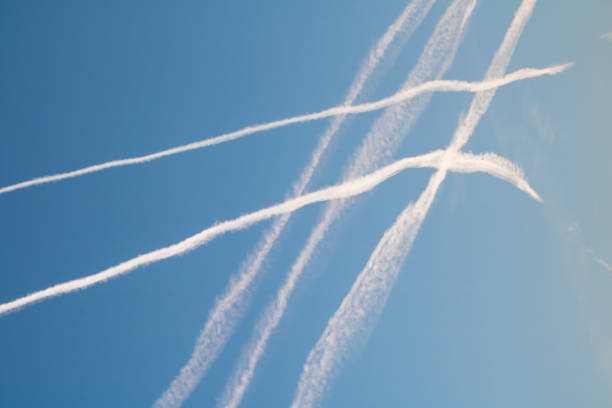 istock crossing plane trails in blue sky, travel concept 908696116