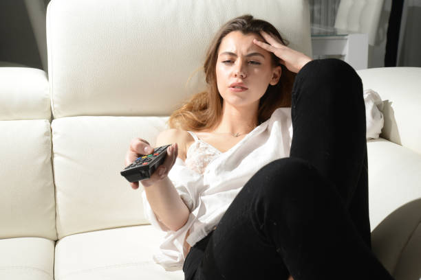 istock beautiful girl is bored watching tv 908699620