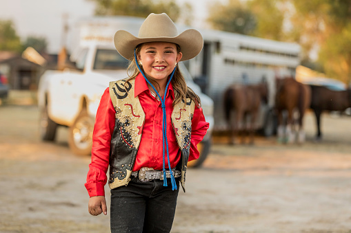 Portrait of a young, dressed up, ready to ride cowgirl