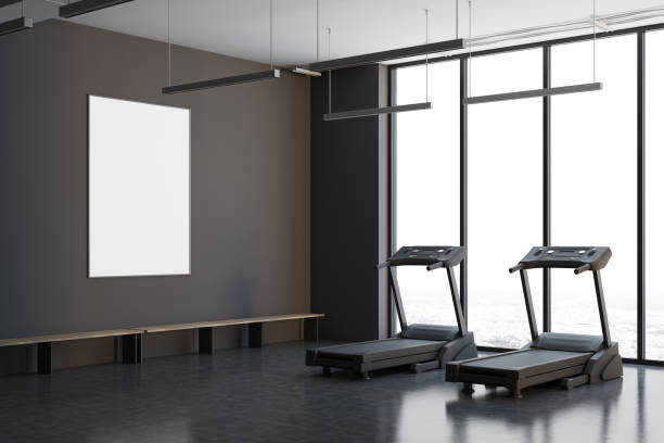 istock Two treadmills in a gray room, side view 908707616