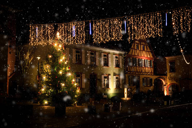 istock Romantic, illuminated Christmas tree during snowfall in the market square of Nierstein 908711214