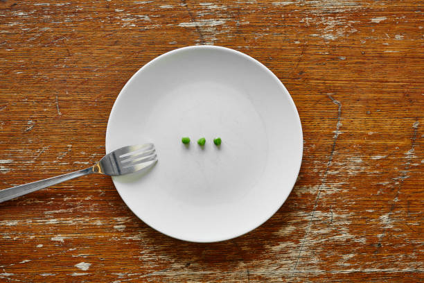 A mid adult Caucasian woman cooking green peas in the kitchen of her apartment