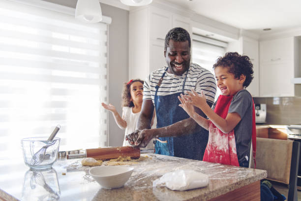 子供と料理の父 - family indoors happiness laughing ストックフォトと画像