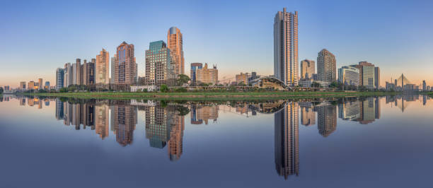 Skyline at sunset, with reflections of buildings on the Pinheiros River in Sao Paulo, Brazil stock photo