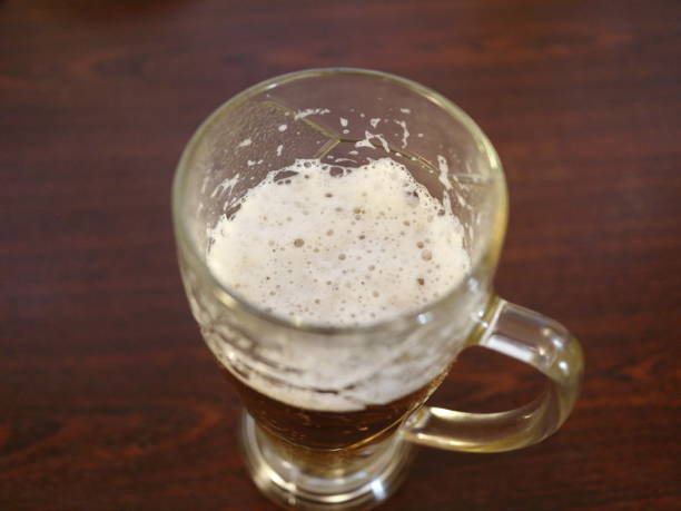 istock a beer mug on a dark table by the window 908738318