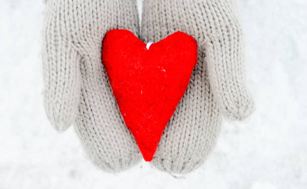istock Hands in gloves holding red heart 908744926