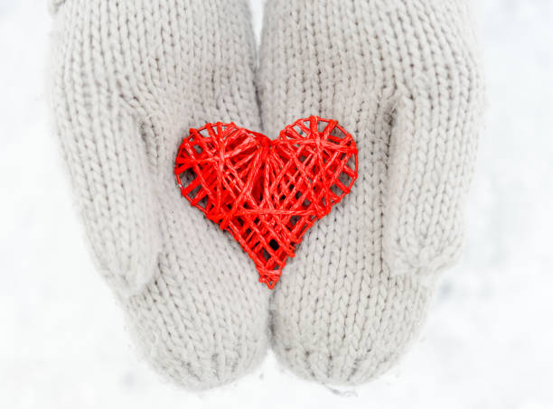 istock Hands in gloves holding red heart 908744960