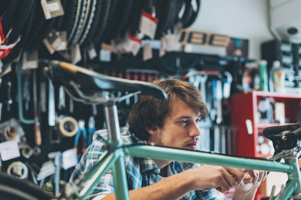 istock Busy young mechanic working on a broken bike 908745088