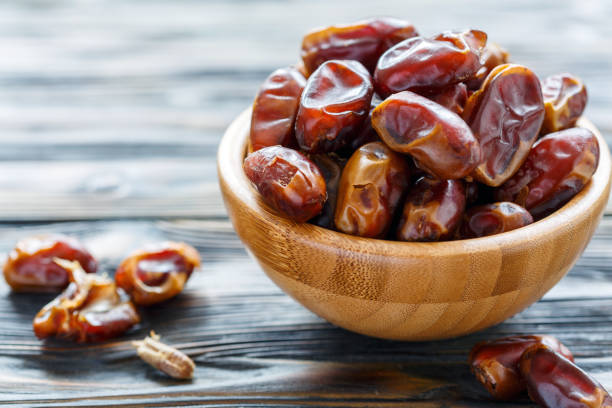 istock Dried date fruit in a wooden bowl. 908749756