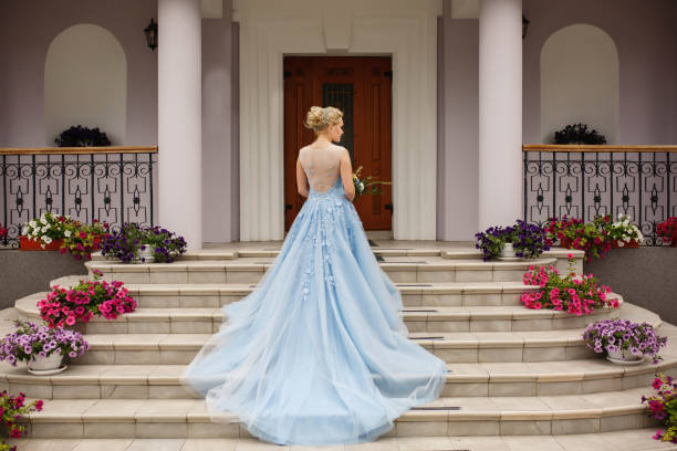 mariage. mariée en robe de mariée bleue dans les escaliers avec des fleurs - robe de mariée photos et images de collection