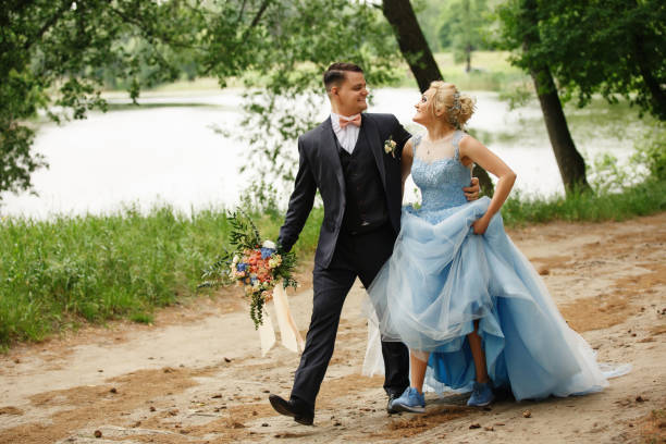 conceito de casamento criativo. casal de noivos andando na floresta, noiva, vestido de noiva azul e sapatos esporte azul - 11270 - fotografias e filmes do acervo