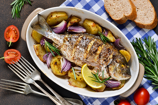 Baked dorado with Provencal herbs and potatoes.