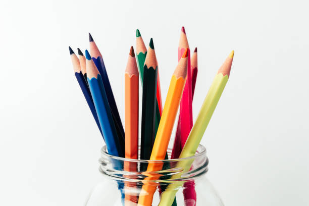 Stack of colored pencils in a glass on white background
