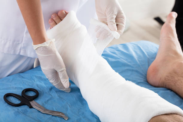 istock Doctor Tying Bandage On Person's Foot 908764846