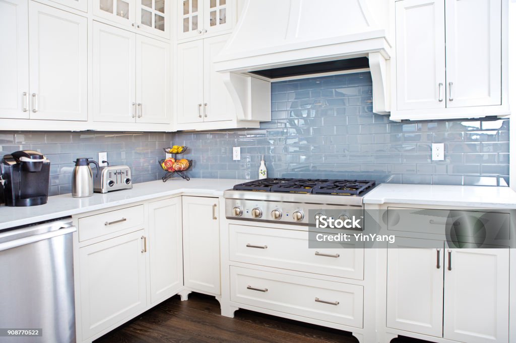 Modern Kitchen Design with Stainless Appliance A contemporary home kitchen with stainless steel appliances and painted white cabinets. Kitchen Stock Photo