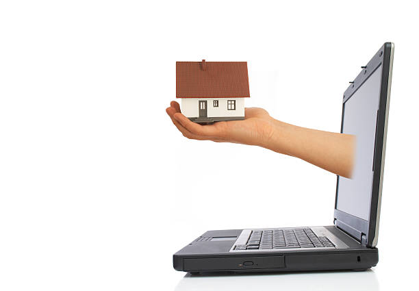 istock Hand protruding from a laptop holding a small house 90877894
