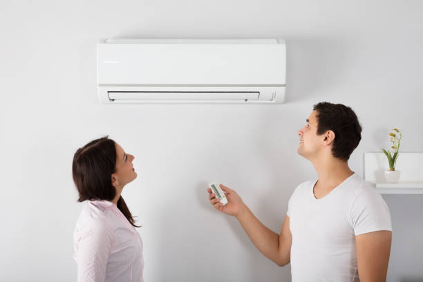 istock Couple Adjusting Temperature Of Air Conditioner 908785946