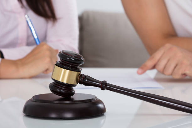 istock Couple Having Discussion Over Document In Courtroom 908785948